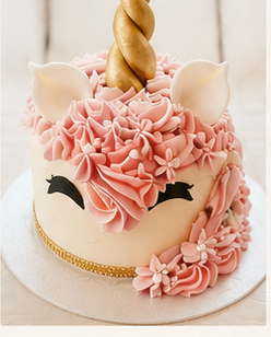 Pink unicorn celebration cake with gold horn and buttercream floral mane